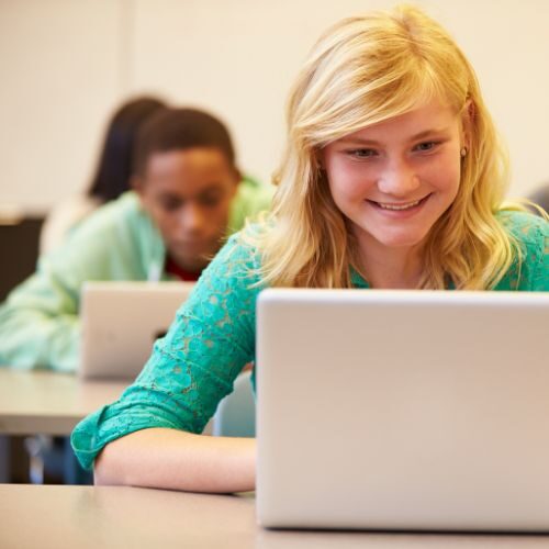 Teenager smiling while using a computer
